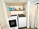 A laundry closet features a front loading washer and dryer along with storage space and laundry detergents at 635 Sw Queen Sw St, Atlanta, GA 30310