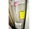 Close-up shot of a grey Rheem water heater with yellow Energy Guide sticker attached to the side at 635 Sw Queen Sw St, Atlanta, GA 30310