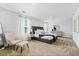 Well-lit bedroom with plush bed, stylish furniture, and ample natural light from large windows at 734 Great Oak Pl, Villa Rica, GA 30180