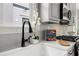 Close up of kitchen farm sink with modern faucet with stainless appliances and gas range in the background at 106 Hogue St, Atlanta, GA 30312