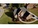Aerial view of brick home, lush lawn, landscaped front yard, and circular driveway in a residential neighborhood at 3240 Letha Woods Sw Dr, Conyers, GA 30094