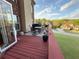 Back deck overlooking the lawn features an outdoor dining table, a grill, and lush green landscaping at 3240 Letha Woods Sw Dr, Conyers, GA 30094