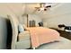 Bedroom with a carpeted floor, ceiling fan, and a bed with a patterned headboard and peach bedding at 3240 Letha Woods Sw Dr, Conyers, GA 30094