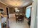 Dining room boasts carpeted floors, brown walls, white molding, hanging light, window, and dining table with six chairs at 3240 Letha Woods Sw Dr, Conyers, GA 30094