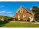 Charming two-story brick home with well-manicured lawn, established landscaping, and blue sky at 3240 Letha Woods Sw Dr, Conyers, GA 30094