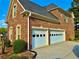 Exterior view of the home showcasing a two-car garage, brick facade, and landscaped surroundings at 3240 Letha Woods Sw Dr, Conyers, GA 30094