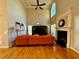 Living room with fireplace, high ceilings, hardwood floors, windows, and orange couch at 3240 Letha Woods Sw Dr, Conyers, GA 30094