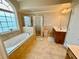 Elegant main bathroom with a jacuzzi tub, walk-in shower, double sink vanity, and bright natural light at 3240 Letha Woods Sw Dr, Conyers, GA 30094