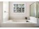 Bathroom features a jetted tub with jets, a glass shower, and a window at 3969 Bear Ridge Nw Pl, Kennesaw, GA 30144