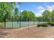 Well-maintained tennis court surrounded by lush greenery and a secure fence at 3969 Bear Ridge Nw Pl, Kennesaw, GA 30144