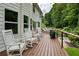 Relaxing deck with rocking chairs, lounge chairs, and grilling area overlooking the backyard at 6765 Creek View Ln, Cumming, GA 30041