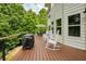 Outdoor deck features rocking chairs, dining table, and grill area with views of the backyard at 6765 Creek View Ln, Cumming, GA 30041