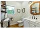 Traditional bathroom featuring stylish decor, hardwood floors, a marble vanity, and ample natural light at 6765 Creek View Ln, Cumming, GA 30041