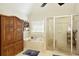 Bright bathroom with a luxurious shower, large soaking tub, and wooden storage cabinet at 6765 Creek View Ln, Cumming, GA 30041