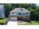 Inviting two-story home with beautiful landscaping, a two-car garage, and a charming front porch area at 6765 Creek View Ln, Cumming, GA 30041