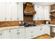 This kitchen features white cabinets, stainless appliances, stone counter tops, and a beautiful brick backsplash wall at 6765 Creek View Ln, Cumming, GA 30041