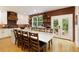 Bright kitchen features a long island with a stone countertop, white cabinetry, stainless appliances, and brick accent wall at 6765 Creek View Ln, Cumming, GA 30041