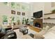 Spacious living room with a fireplace, large windows, hardwood floors, and comfortable seating at 6765 Creek View Ln, Cumming, GA 30041