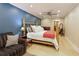 Spacious bedroom boasts a rustic bed frame, comfortable sofa and soothing blue accent wall at 6765 Creek View Ln, Cumming, GA 30041