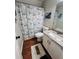 Cozy bathroom featuring a turtle-themed shower curtain, marble countertop vanity, and wood-look flooring at 102 Collins Way, Douglasville, GA 30134