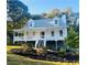 Charming two-story white home featuring a welcoming front porch and well-manicured landscaping at 102 Collins Way, Douglasville, GA 30134