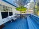 Relaxing back patio featuring an umbrella covered table and chair set along with a blue bench at 102 Collins Way, Douglasville, GA 30134