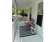 Inviting covered porch featuring a red chair, black and white rug, and stylish decor at 102 Collins Way, Douglasville, GA 30134