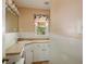 Bright bathroom with a window, white cabinets, and earth-toned countertops at 1336 Shirley Dr, Sugar Hill, GA 30518