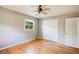 Bright bedroom with hardwood floors, a double closet, and a ceiling fan at 1336 Shirley Dr, Sugar Hill, GA 30518