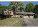 Charming brick home with manicured lawn, mature trees, and a split-level design creates a welcoming curb appeal at 1336 Shirley Dr, Sugar Hill, GA 30518