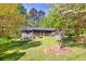 Beautiful house with green front lawn, a screened porch and lush trees at 1878 Suwanee Roberts Ct, Lawrenceville, GA 30043