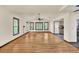 Bright living room with hardwood floors, white walls, windows, and a ceiling fan, with access to the kitchen at 1878 Suwanee Roberts Ct, Lawrenceville, GA 30043