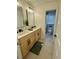 Bathroom with double sinks, modern light fixtures, and walk-in shower at 6501 Menlo Way, Rex, GA 30273