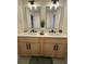 Bright bathroom features double sinks, modern vanity, and two decorative mirrors with elegant overhead lighting at 6501 Menlo Way, Rex, GA 30273