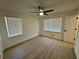 Bedroom with modern fan and neutral walls features wood-look flooring and two windows with natural lighting at 6501 Menlo Way, Rex, GA 30273