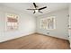 Inviting bedroom with wood-look flooring features neutral walls, two windows, and modern fan at 6501 Menlo Way, Rex, GA 30273
