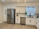 Kitchen featuring stainless steel refrigerator, dishwasher, and white cabinets and modern backsplash at 6501 Menlo Way, Rex, GA 30273