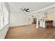 Living room with hardwood floors adjacent to kitchen and bar with modern pendant lighting at 6501 Menlo Way, Rex, GA 30273