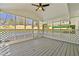 Enclosed white patio features a ceiling fan, white wood flooring, and view of the backyard at 6501 Menlo Way, Rex, GA 30273