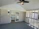 Enclosed patio features a ceiling fan, gray wood flooring, and view of the backyard at 6501 Menlo Way, Rex, GA 30273