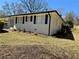Side view of renovated home with painted brick, black shutters, and manicured landscaping at 6501 Menlo Way, Rex, GA 30273