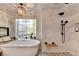 This luxurious bathroom features a modern tub, rainfall shower, and a decorative chandelier at 10355 Oxford Mill Cir, Johns Creek, GA 30022