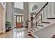 Foyer featuring wood floors, staircase and a decorative wood and glass front door at 10355 Oxford Mill Cir, Johns Creek, GA 30022