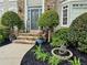 Inviting front entrance with stone steps, manicured plants, and decorative water feature at 10355 Oxford Mill Cir, Johns Creek, GA 30022