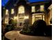 Stately home facade with a stone exterior and illuminated windows creating a warm and inviting ambiance at night at 10355 Oxford Mill Cir, Johns Creek, GA 30022