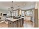 Open-concept kitchen featuring a large island with cooktop and barstool seating with easy access to the dining and living areas at 10355 Oxford Mill Cir, Johns Creek, GA 30022
