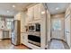 Bright kitchen features stainless steel appliances, white cabinetry, and an exterior door at 10355 Oxford Mill Cir, Johns Creek, GA 30022