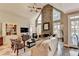 Bright living room with vaulted ceiling, stone fireplace and a view to the backyard at 10355 Oxford Mill Cir, Johns Creek, GA 30022