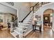 Staircase featuring wood steps and floors, a dark wood banister, and views of another room at 10355 Oxford Mill Cir, Johns Creek, GA 30022