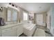 Bright bathroom featuring a soaking tub, double vanity, and a separate glass-enclosed shower for a luxurious experience at 147 Johnston Farm Ln, Woodstock, GA 30188
